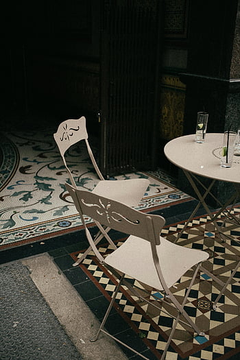 white metal chairs, round table, outdoor cafe, London, charming seating area, tile patterns, metal folding chairs, cafe table, outdoor seating, cafe chairs, London cafe