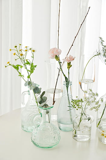 bloemen in vazen, helderglazen vazen, minimalistische regeling, verse bloemen, bloemstengels, tafel opstelling, delicate bloemen, minimalistisch decor, vers bloemstuk, duiden vazen, minimalistische bloemen