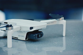 white drone, drone camera, close-up photo, reflective surface, sleek design, DJI Mavic Mini, ultra-light drone, 249g drone, aerial photography, drone technology, close-up shot