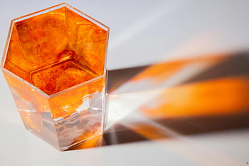 glass, colorful water, paint flows, orange dye, hexagonal glass, vibrant flow, dynamic reflections, surface, artistic photography, abstract art, fluid dynamics