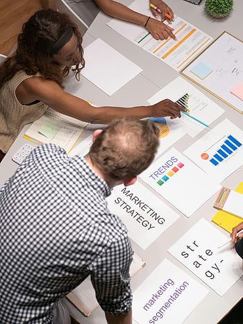 top view, people in meeting, marketing strategies, modern office, charts, documents, team discussion, trends, marketing strategy, segmentation, office setting
