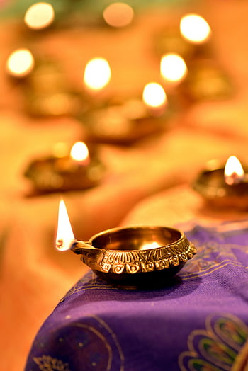Diwali, Diya, lighted Diya, close up shot, decorative diyas, warm glowing lights, Diwali festival, India, night illumination, festive lights, purple cloth