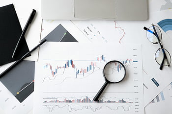 magnifying glass, stock market analysis, documents, flat lay, pens, glasses, financial charts, investment analysis, business documents, office desk, market data