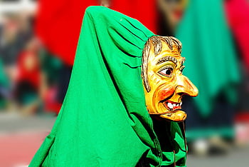 Yellow and Green Mask Man, colorful wooden witch mask, carnival scene, green cloak, close-up, wooden mask, witch mask, carnival, green background, colorful mask, wooden witch