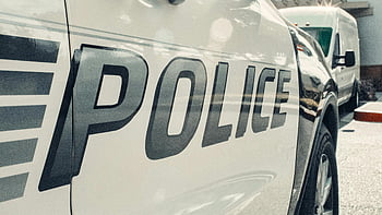 police vehicle, close-up shot, reflective text, urban setting, police car, law enforcement, emergency services, public safety, vehicle side, city street, police department