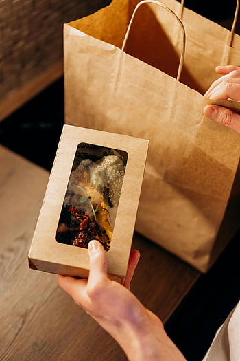 food delivery, eco-friendly packaging, cardboard box, paper bag, wooden surface, hands holding, sustainable delivery, takeaway food, eco packaging, food container, eco-friendly food delivery