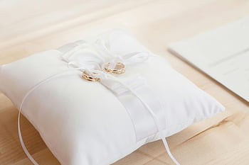 gold bridal rings, white satin pillow, wedding rings, love and commitment, closeup photo, elegant display, gold wedding rings, white pillow, ring bearer pillow, romantic symbol, bridal accessories