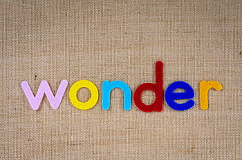 wonder, colorful felt letters, burlap background, creative designs, woven surface, felt words, decorative text, craft materials, handmade art, textile art, word art