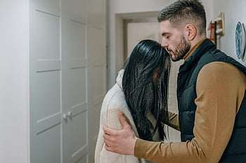 coppia, momento tenero, Scena intima, impostazione interna, emozione genuina, uomo che tiene le braccia, braccia di donna, Abbraccio vicino, interazione romantica, Connessione sentita, Coppia indoor
