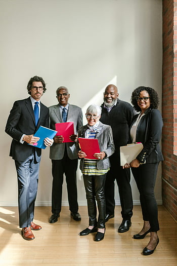 group of people, happily standing, holding folders, diverse group, professionals, bright office setting, office environment, business people, smiling group, workplace diversity, team collaboration