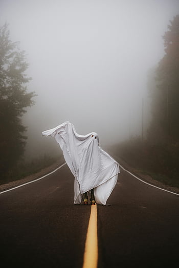 costume fantasma, strada nebbiosa, Halloween spettrale, persona misteriosa, Atmosfera di Halloween, Figura spettrale, Atmosfera nebbiosa, scena stradale, costume di Halloween, scena inquietante, Presenza spettrale