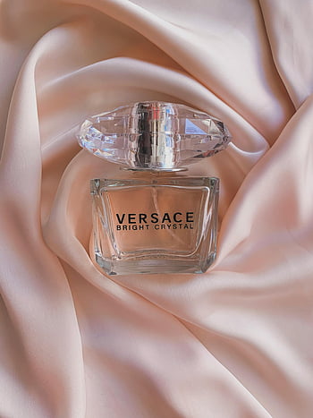 Versace Bright Crystal, parfémy láhev, skleněná láhev, Růžové hedvábí, Luxusní vůně, elegantní design, Parfém Versace, Křišťálová čepice, Měkká tkanina, špičkový parfém, kosmetický výrobek