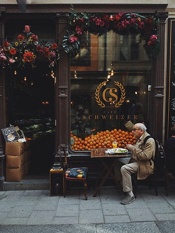 man i brun jacka, sitter på stol, fruktstånd, pittoreska gata kafé, stockholm, äldre man, njuter av måltid, Vackert dekorerad butik, visa, uteservering, kafé schweizer