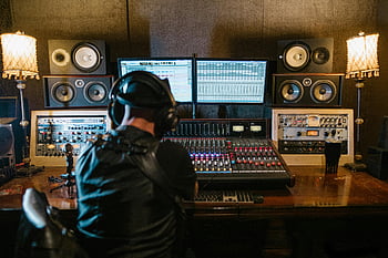 musikproducent, inspelningsstudio, ljudutrustning, blandningskonsol, dator, hörlurar, mysig miljö, soundboard, högtalare, skrivbord, lampor