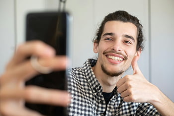 selfie, smilende mann, Svart og hvitt rutete, lange ermer, tommel opp, innendørs foto, smarttelefon, ung mann, Uformell stil, lykkelig uttrykk, selfie-gest