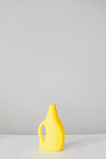 yellow detergent bottle, cleaning product, white surface, ample copy space, plastic bottle, laundry detergent, household cleaner, minimalistic background, product photography, yellow bottle, white table