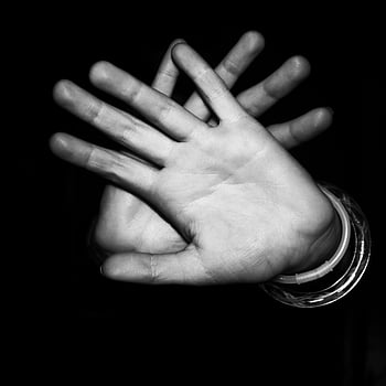handen, monochroom, detailopname, stop gebaar, donkere achtergrond, zwart en wit, pols armbanden, menselijke handen, gebaarfotografie, hoog contrast, schaduwspel