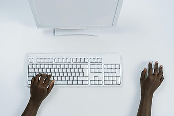 top view, minimalist workspace, white computer set, dark-skinned hands, using mouse, keyboard, workspace photography, computer setup, clean desk, productivity, ergonomic design