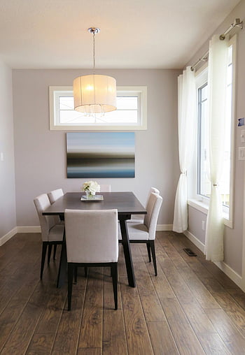 hnědý dřevěný jídelní stůl, Beige Přívěsek, Současná jídelna, minimalistický dekor, moderní nábytek, Světlá jídelna, dřevěná podlaha, abstraktní zdi umění, bílé židle, velké okno, přirozené světlo