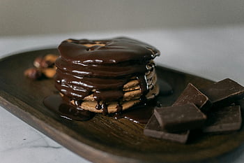 pancakes, melted chocolate, chocolate syrup, wooden board, chocolate blocks, stack of pancakes, drizzled chocolate, dessert, breakfast, food photography, chocolate drizzle