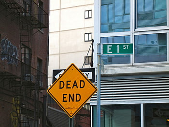 dead end, road sign, city intersection, urban buildings, street sign, E 1 ST, yellow sign, traffic sign, street corner, building exterior, cityscape