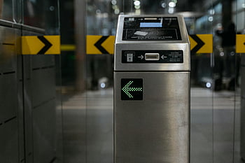 automated ticket machine, modern ticket gate, illuminated arrow, access control, transit systems, ticket validation, public transportation, entry gate, electronic ticketing, transportation technology, transit security
