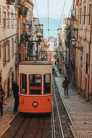 Lisbon, Portugal, historic tram, picturesque street, vibrant urban life, tram between buildings, cobblestone street, European architecture, cityscape, travel destination, street scene