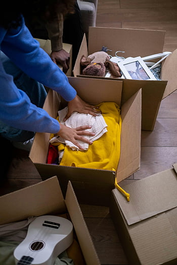 packing clothes, cardboard box, organizing clothes, moving boxes, storage boxes, toys in boxes, people packing, moving day, storage organization, cardboard storage, packing for move