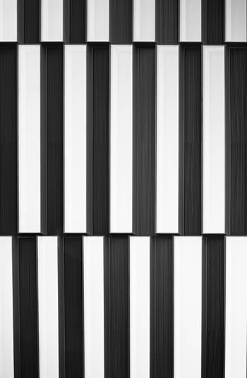 black and white stripes, vertical geometric pattern, modern building facade, stylish design, black and white illustration, architectural detail, contemporary architecture, geometric design, monochrome pattern, vertical stripes, modern facade
