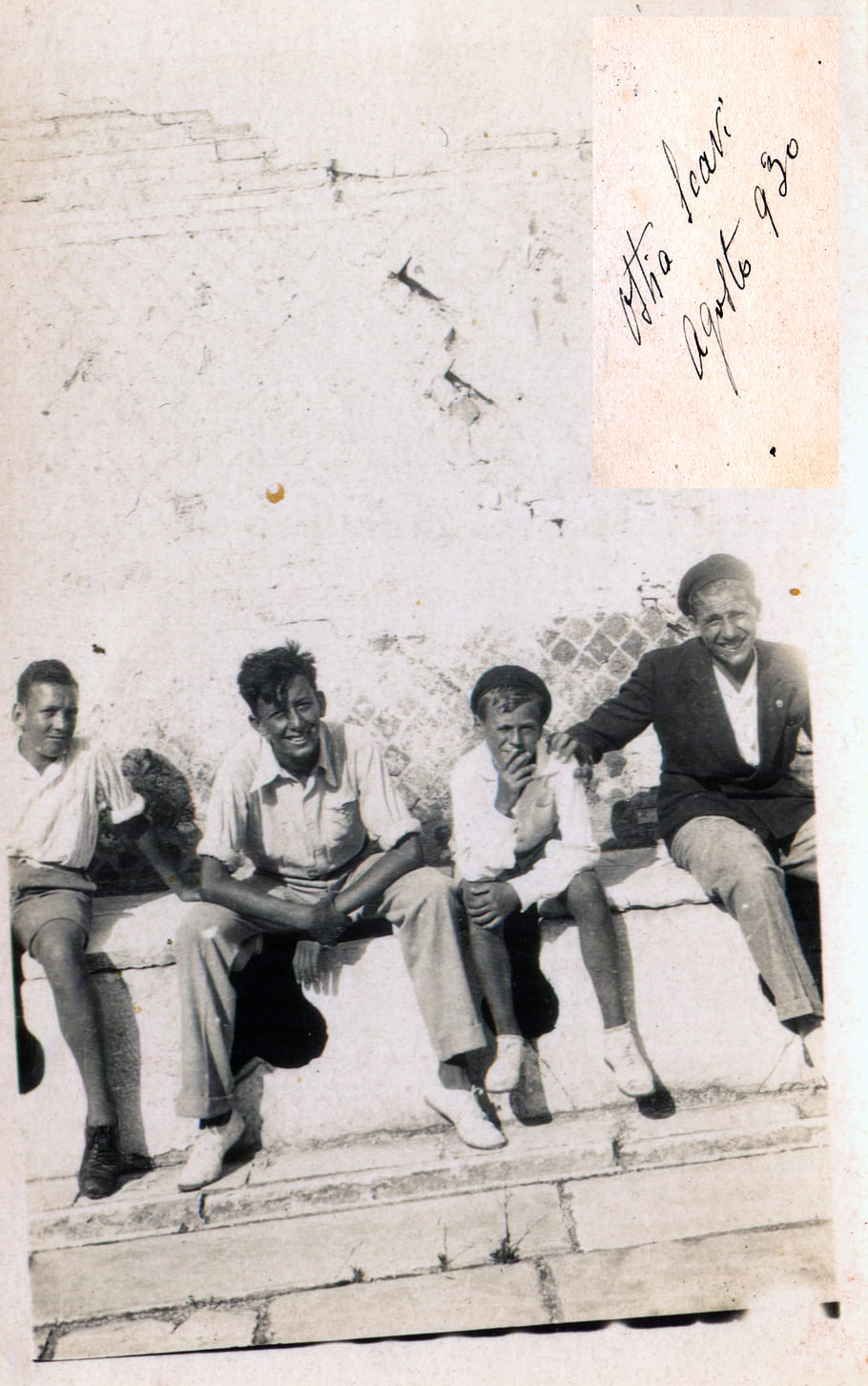 black and white, vintage photo, group of people, sitting on steps, smiling, casual clothing, old photograph, handwritten note, historical image, outdoor setting, August 1930