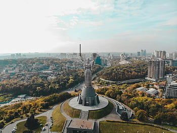 Motherland Monument, Kyiv cityscape, drone shot, clear day, aerial view, Kyiv skyline, urban landscape, Motherland statue, city panorama, Ukraine landmark, autumn foliage