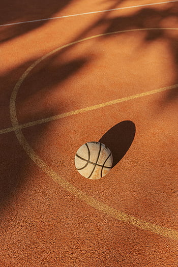 basketball, clay court, outdoor court, shadows, warm lighting, sports, ball, court lines, sports equipment, recreation, outdoor sports