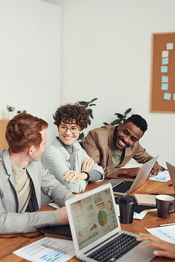 équipe diversifiée, séance de remue-méninges, bureau moderne, ordinateurs portables, documents, travail collaboratif, réunion professionnelle, environnement de bureau, discussion d'équipe, interaction en milieu de travail, Utilisation de la technologie