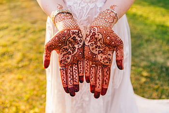 henna tattoo, hands with henna, intricate henna art, white dress, outdoor photo, vibrant setting, henna design, henna patterns, traditional henna, henna on hands, outdoor henna art