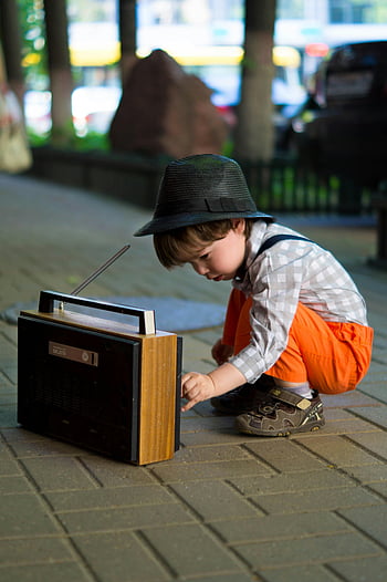 boy, tuning, transistor, radio, young, fashionable, attire, old-fashioned, outdoors, street, urban