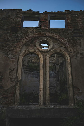 ruined building, old ruins, blue sky, decayed structure, broken windows, historical architecture, weathered building, arched windows, dusk scene, abandoned building, architectural decay