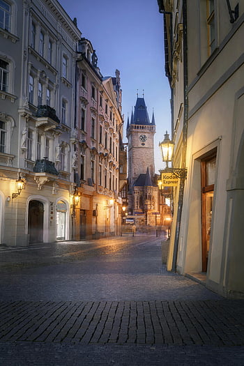 Prague, cobblestone street, historical architecture, twilight scene, architectural buildings, cityscape, Old Town Square, Astronomical Clock, European city, serene atmosphere, street lamps