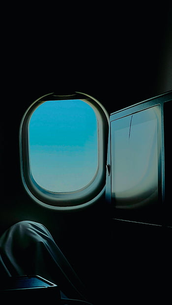 airplane window view, serene flight, clear sky from airplane, peaceful travel, window seat view, sky through airplane window, relaxing in flight, calm flight experience, airplane window scenery