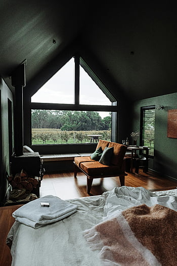 cozy bedroom, modern interior design, lush greenery, bed and sofa, large windows, wooden floor, contemporary furniture, indoor fireplace, comfortable living space, serene view, cozy retreat