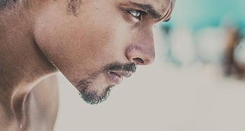 man's face, close-up, side view, young man, serious expression, focused expression, facial features, profile shot, male portrait, beard, stubble