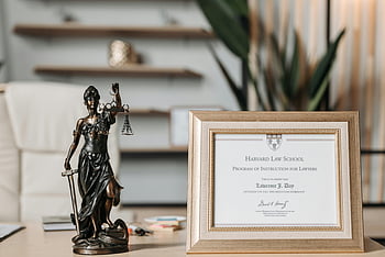 Lady Justice, statuette, Harvard Law School, diploma, framed certificate, office desk, legal profession, justice symbol, educational achievement, professional decor, law school