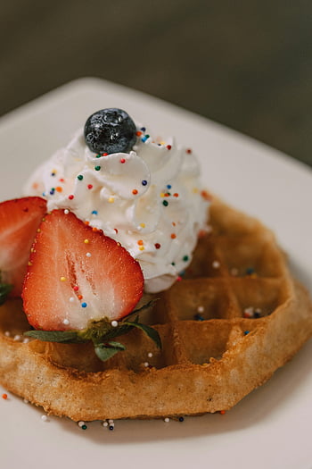strawberry waffle, whipped cream, strawberries, blueberries, close-up shot, waffle dessert, whipped topping, fruit waffle, breakfast dish, colorful sprinkles, sweet treat