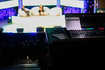 ブラックオーディオアンプ、 サウンドコンソール、 スタジオ設定、 ライブイベント、 ぼやけた聴衆、 オーディオ機器、 音楽制作、 コンサートのセットアップ、 ミキシングコンソール、 舞台装置、 イベントテクノロジー