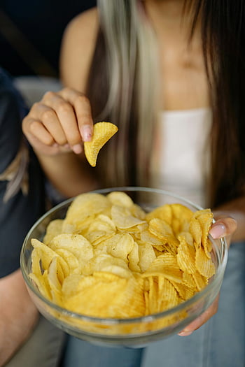 chipsuri, bol de sticlă, gustare timp, Chipsuri crocante, femeie tânără, selectiv, bucurându -se de chipsuri, Snack Delight, Mâncare casual, Moment de gustare, Bowl cu cartofi