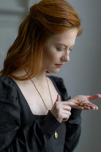 butterfly, woman's palm, red-haired woman, gentle touch, tranquility, connection with nature, butterfly on hand, nature photography, peaceful moment, natural beauty, serene scene