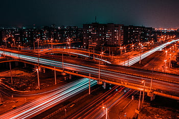 time-lapse photography, road, night view, bustling city, light trails, expressway, dynamic motion, urban scene, long exposure, cityscape, traffic flow