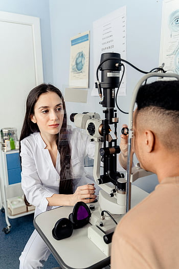 optometrist, eye health assessment, slit lamp, patient examination, indoor clinic, eye care, medical professional, eye doctor, eye exam, healthcare, medical equipment