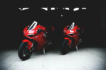 Ducati motorcycles, red Ducati, sports bikes, garage setting, two motorcycles, Ducati bikes, red sports bikes, shadowy garage, Ducati sports bikes, motorcycle photography, Ducati motorbikes