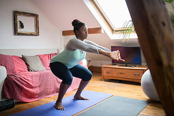 Žena dělá dřepy, natahování paží, Domácí fitness, útulný obývací pokoj, podložka na jógu, Vnitřní cvičení, wellness, cvičení, fitness rutina, domácí cvičení, zdravý životní styl
