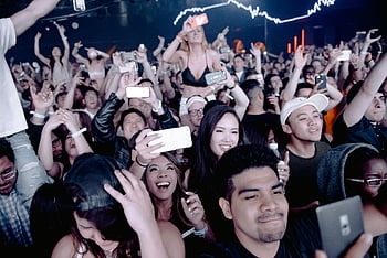 concert crowd, smartphones, live concert, excited crowd, capturing moment, people holding smartphones, concert photography, concert attendees, smartphone photography, concert atmosphere, crowd engagement
